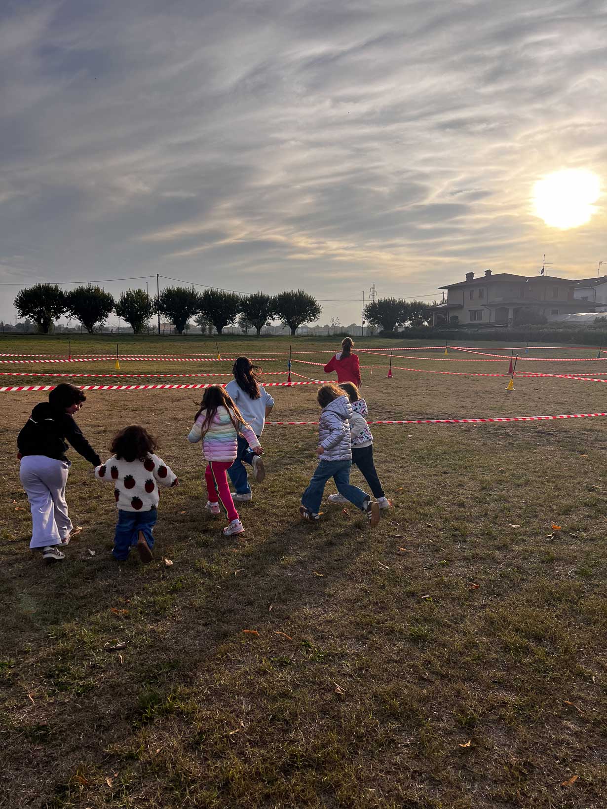 Bambini corrono lungo il percorso della corsa campestre “Un giro tira l’altro” nel parco della Casa del Fanciullo.