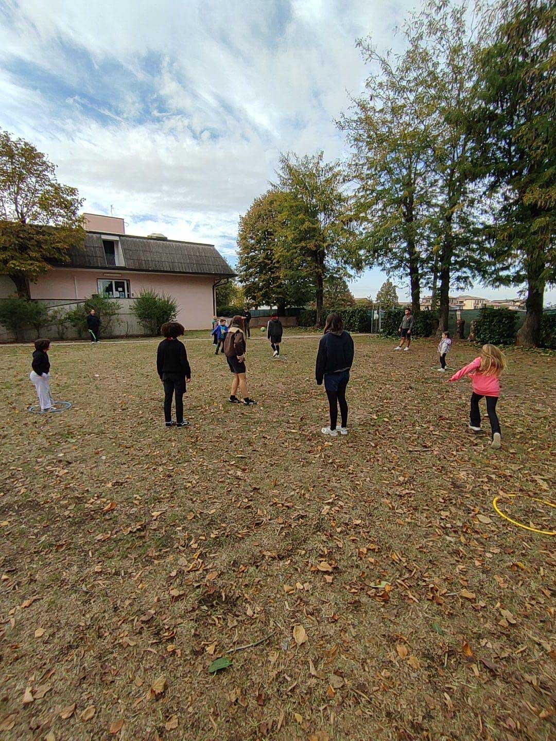 Bambini partecipano alla corsa campestre “Un giro tira l’altro” nel parco della scuola della Casa del Fanciullo.