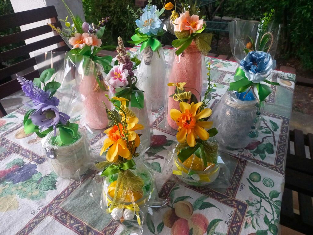 Vasetti e bottigliette decorati a mano dai bambini della Casa del Fanciullo, preparati come piccoli doni per gli ospiti della raccolta benefica.