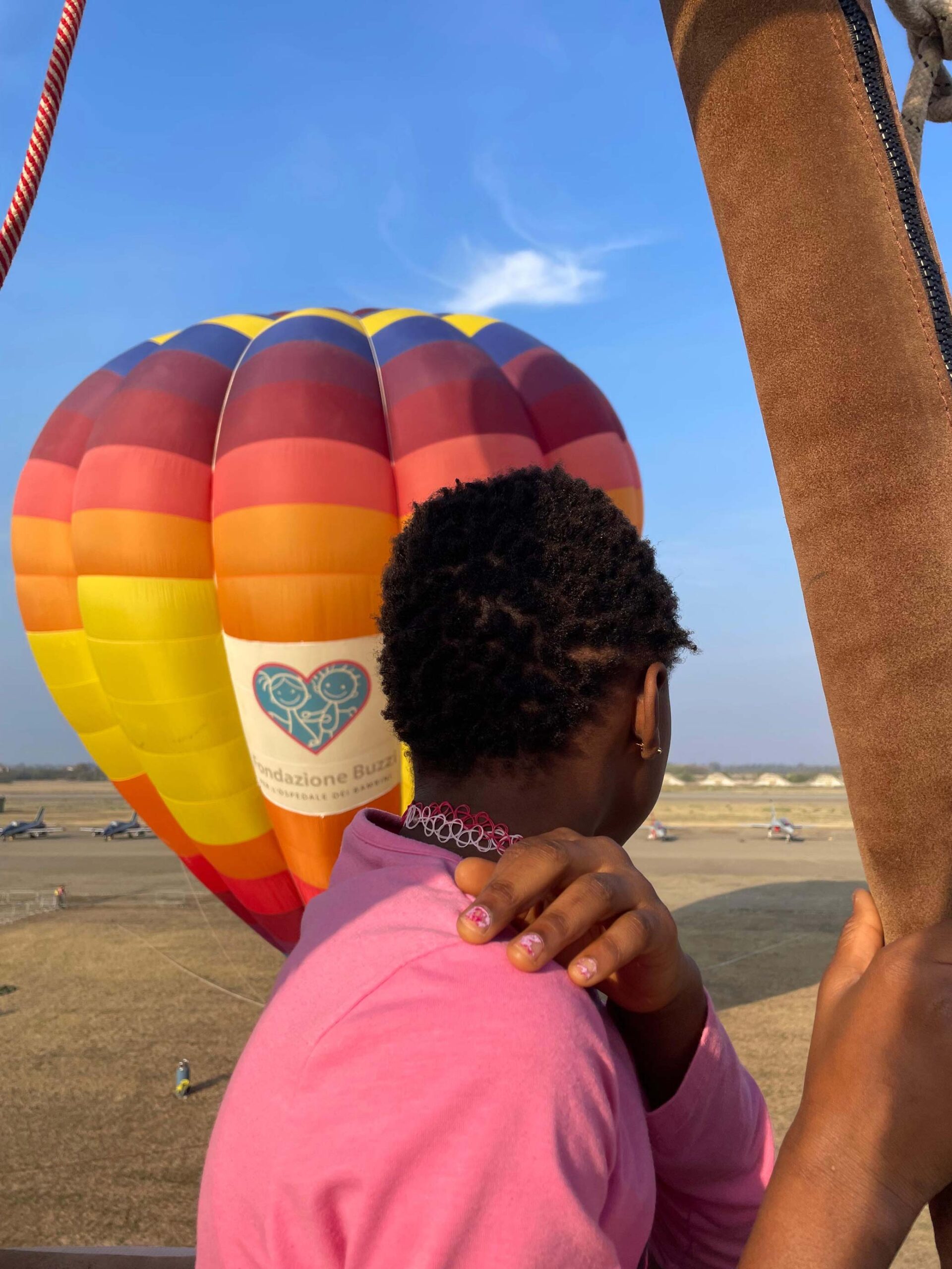 Una ragazza osserva una mongolfiera colorata durante il volo alla Balloon CUP.